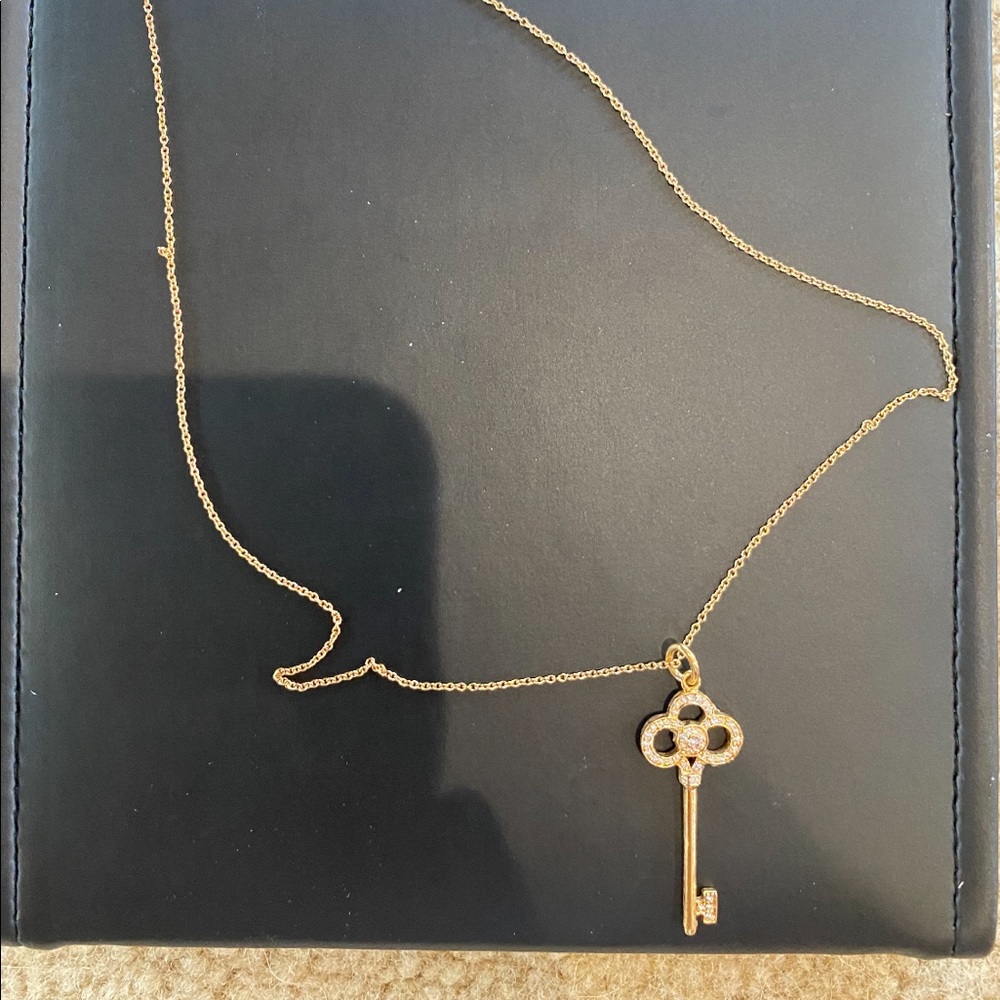 Tiffany fleur de lis key 18 karat gold n diamonds.
